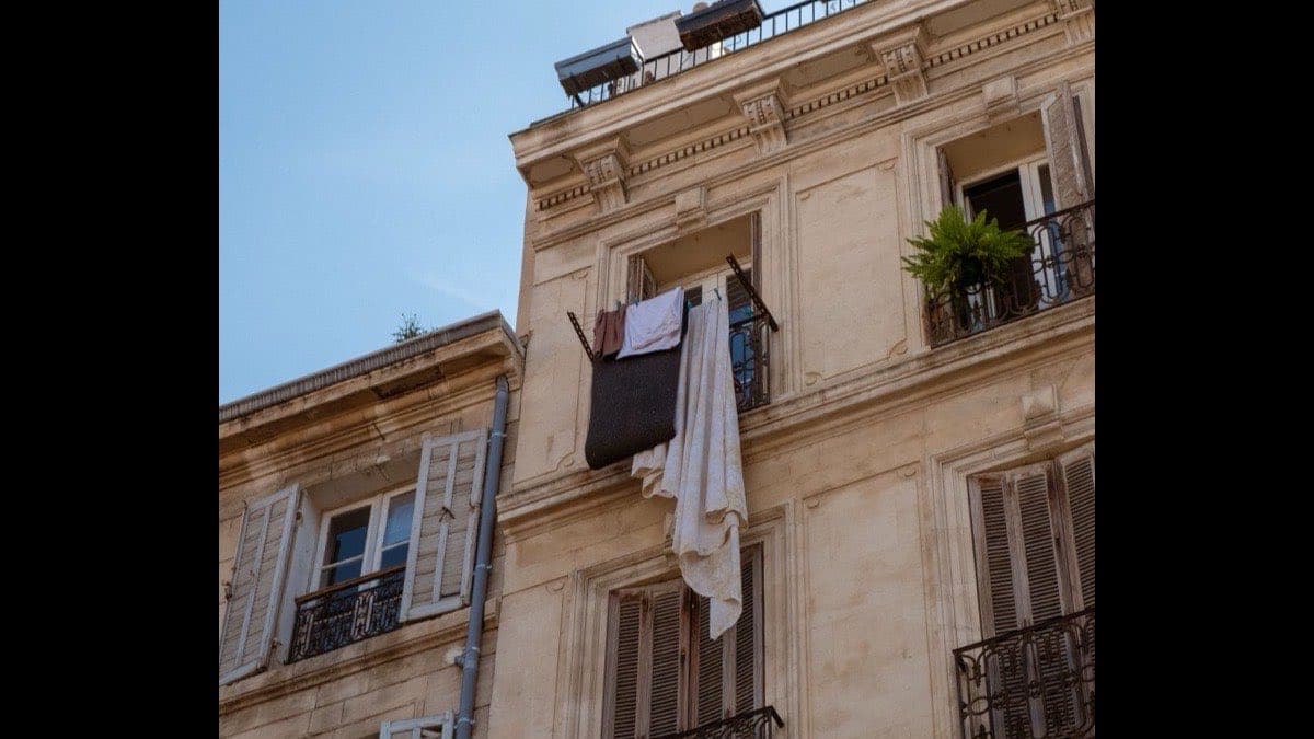 Façade méditerranéenne classique, enduit clair, volets et linge étendu