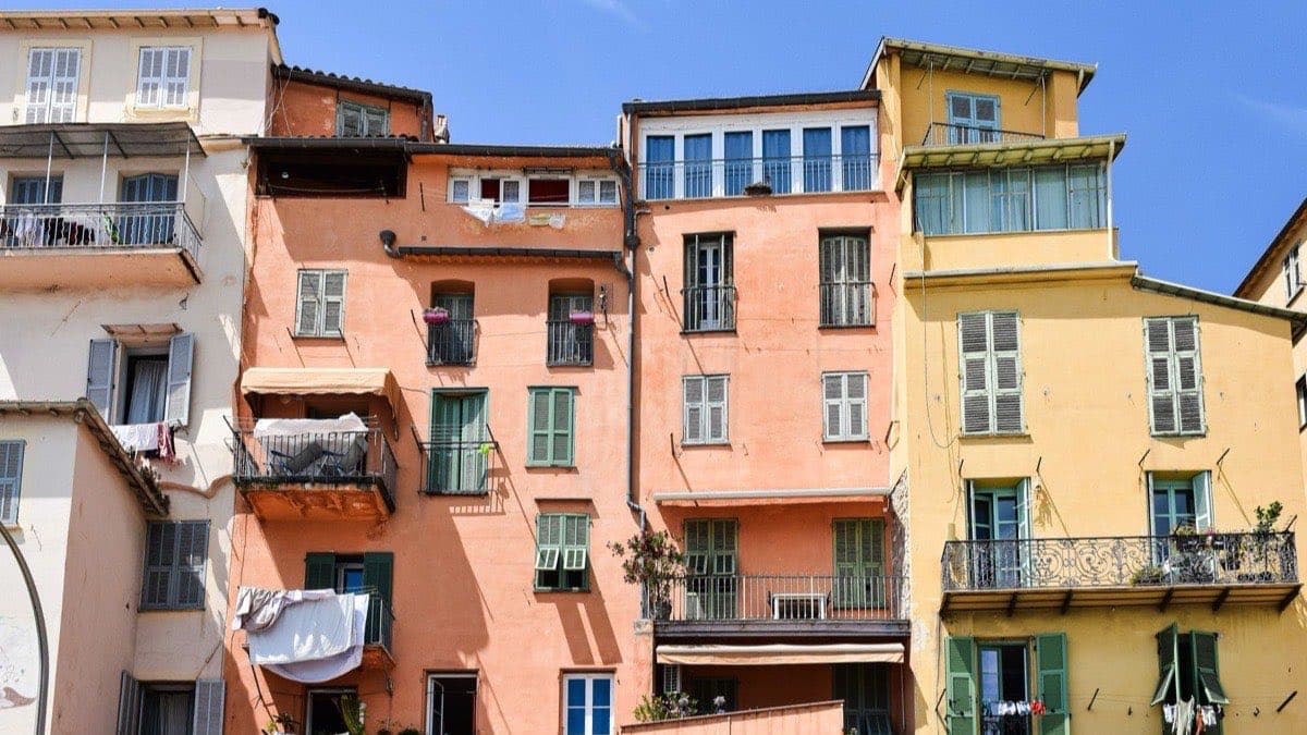Façades colorées d’immeubles anciens en Provence-Alpes-Côte d’Azur, volets bois et linge aux fenêtres